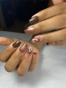 Manicura semipermanente en tonos café cálido y bronce brillante a domicilio por nailsbyeliag